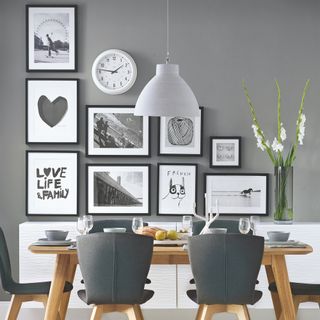 grey dining room with dining table chairs and framed artwork on the wall