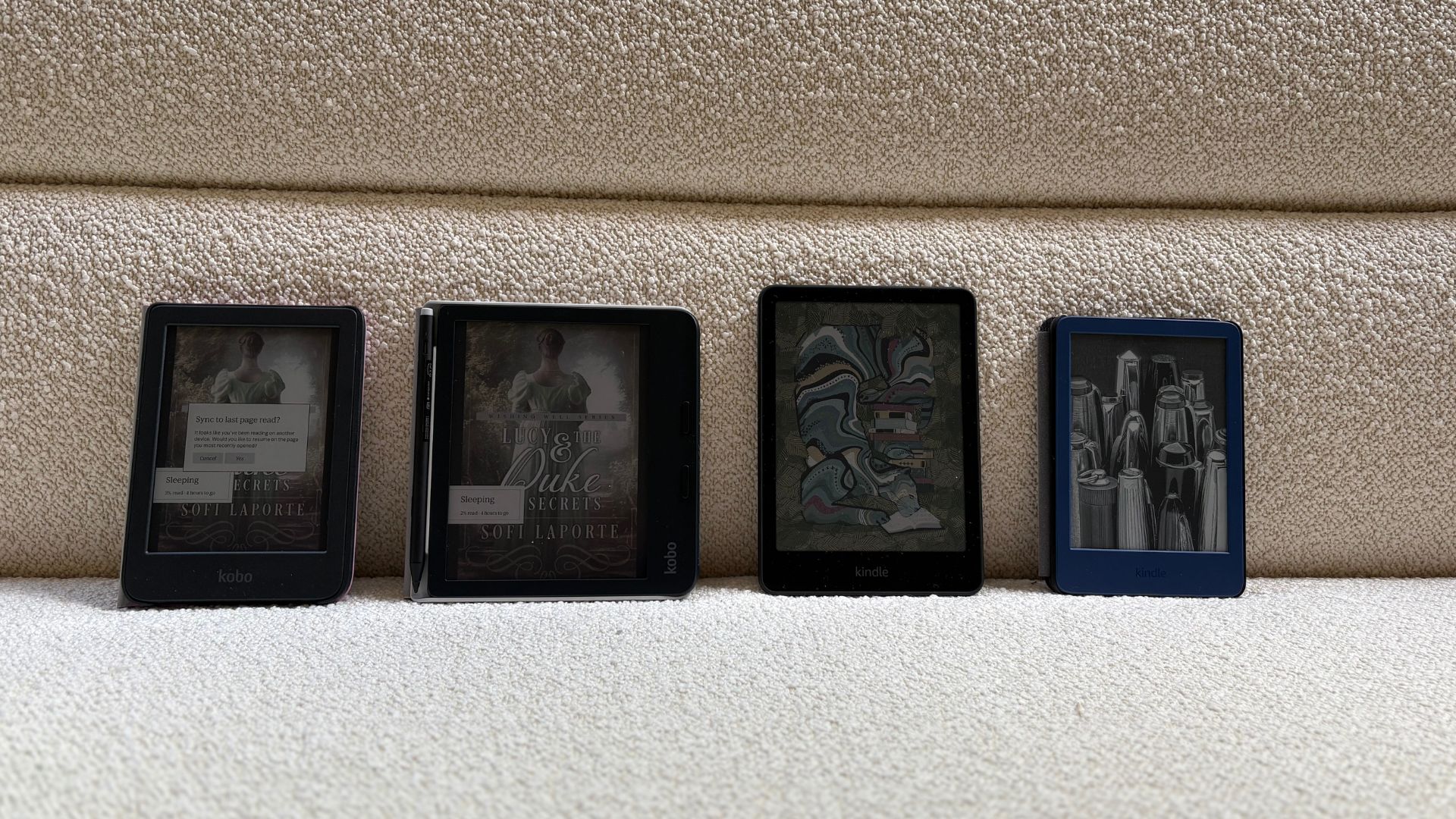 Two Kindles next to two Kobos with the screen on