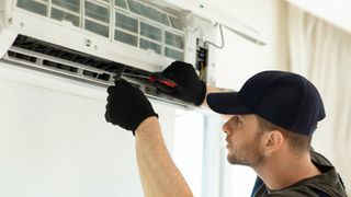 Man fixing air conditioner unit