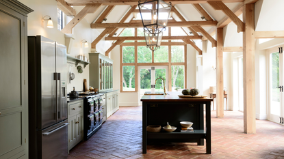 DeVol kitchen with wooden beams, floors, a dark kitchen island and Aga in the left lower kitchen cupboards