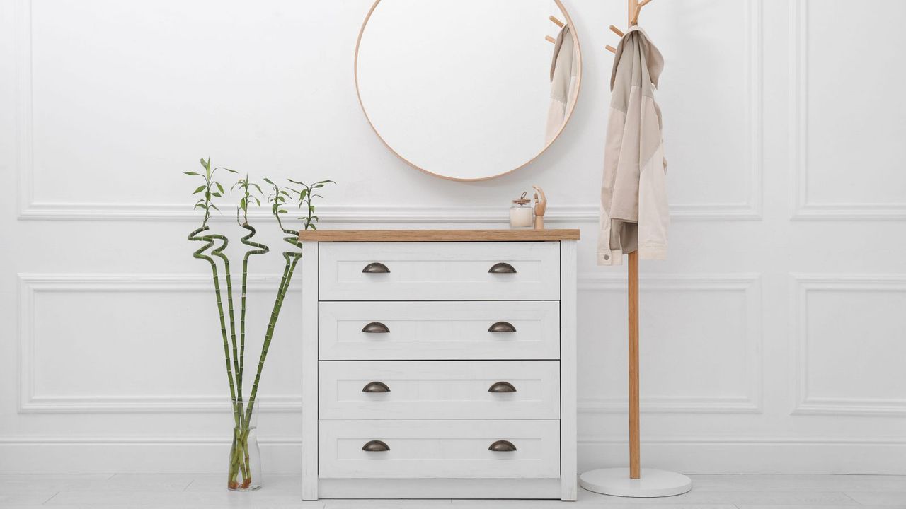 White cabinets, lucky bamboo and coat rack