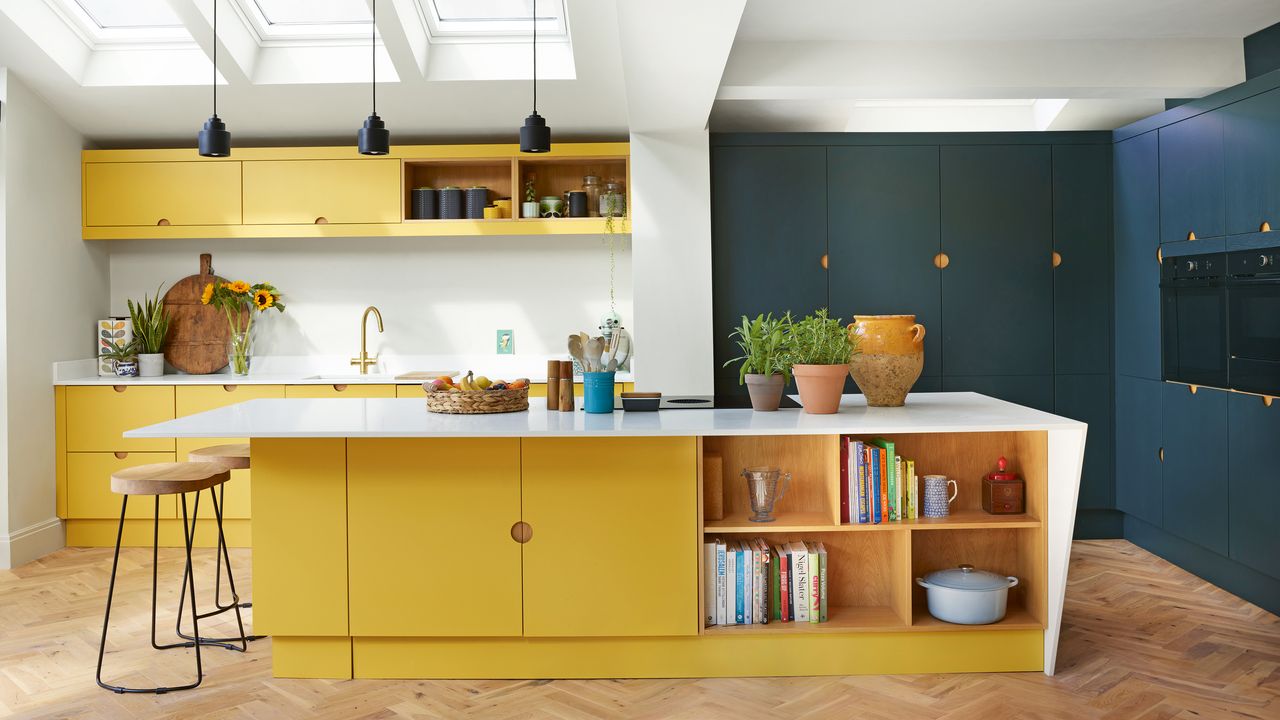 modern yellow and navy blue kitchen with kitchen island, bar stools and three sky lights