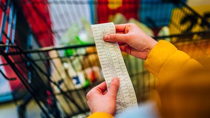 A woman checks her grocery receipt.