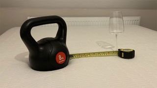 A weight, a wine glass and a tape measure on the REM-Fit 500 Ortho Hybrid mattress