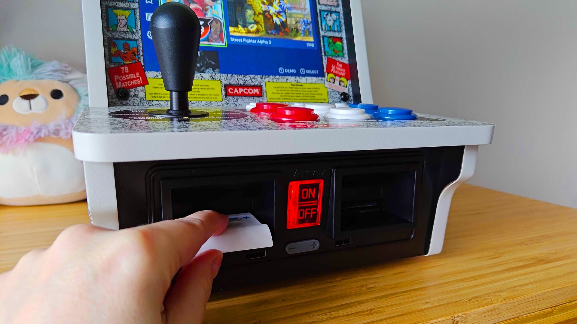 Hand inserting cartridge into Evercade Alpha arcade machine