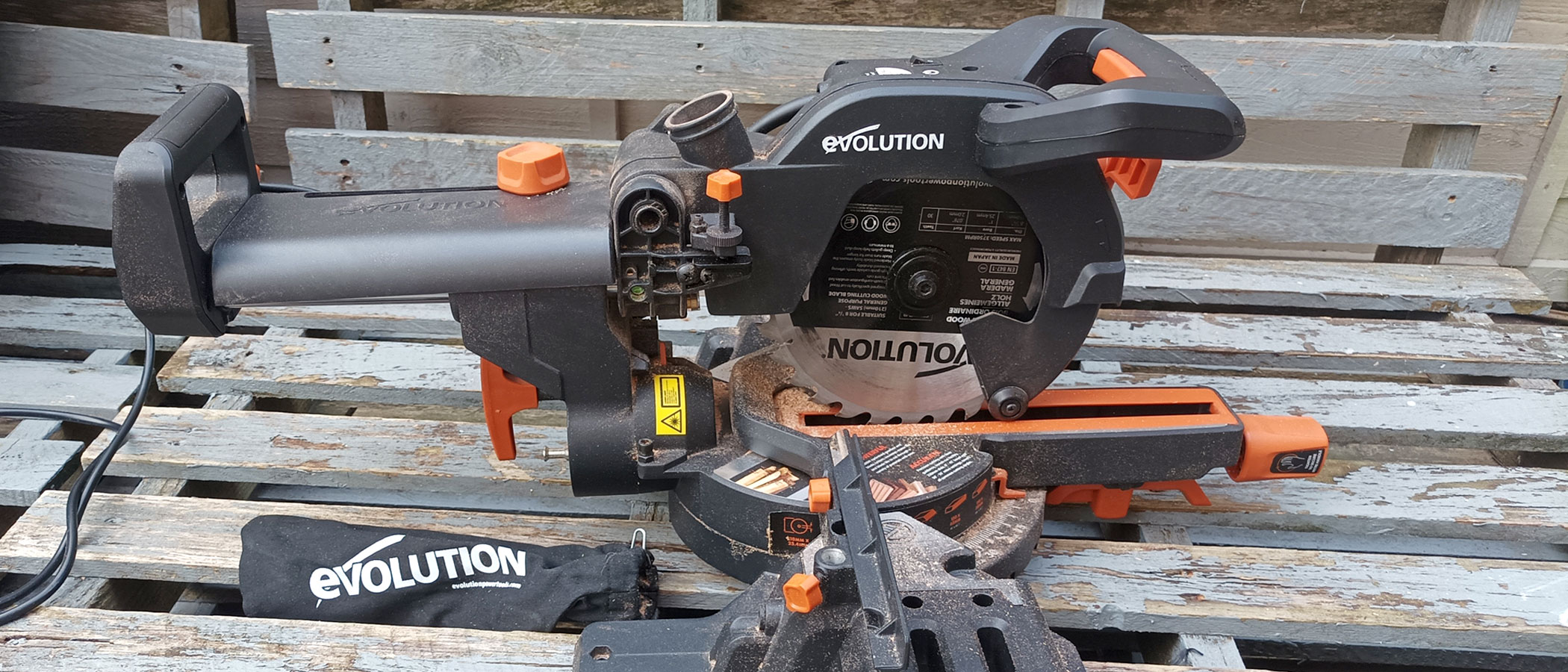 Evolution R210SMS+ 210mm Sliding Compound Mitre Saw on grey wooden pallets