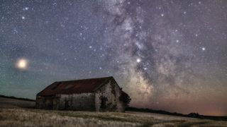 Milky Way over an old barn at night