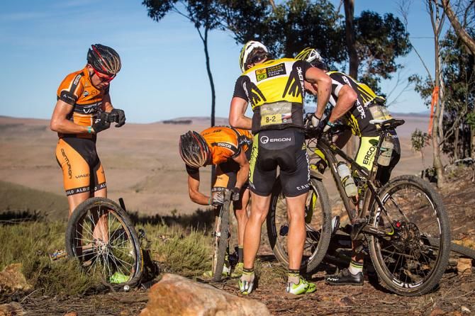 The Centurian Vaude Team assist the Yellow Jersey holders Topeak-Ergon Racing Team after they got a flat tyre during stage 5