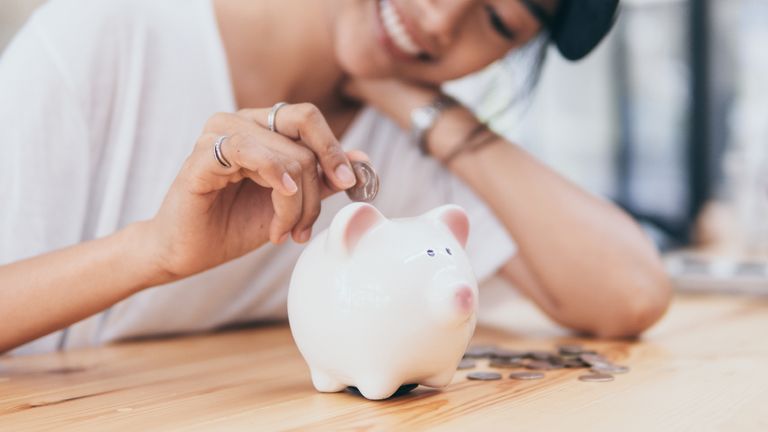 Piggy Bank for saving money.Hand holding money for savings and financial management. - stock photo
