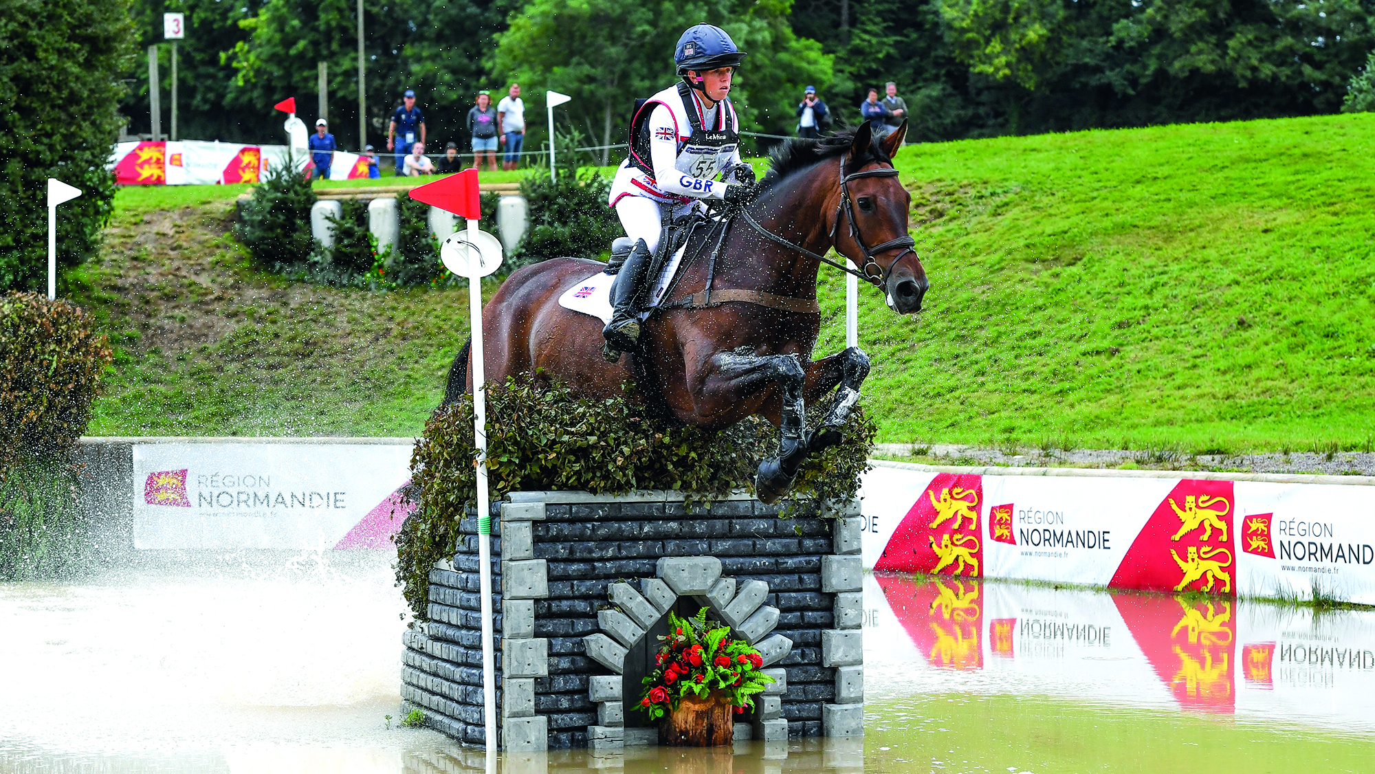 Ros Canter and Lordships Graffalo, British team members for the 2026 World Championships, jump a narrow fence in water at the 2023 European Championships at Haras du Pin, France