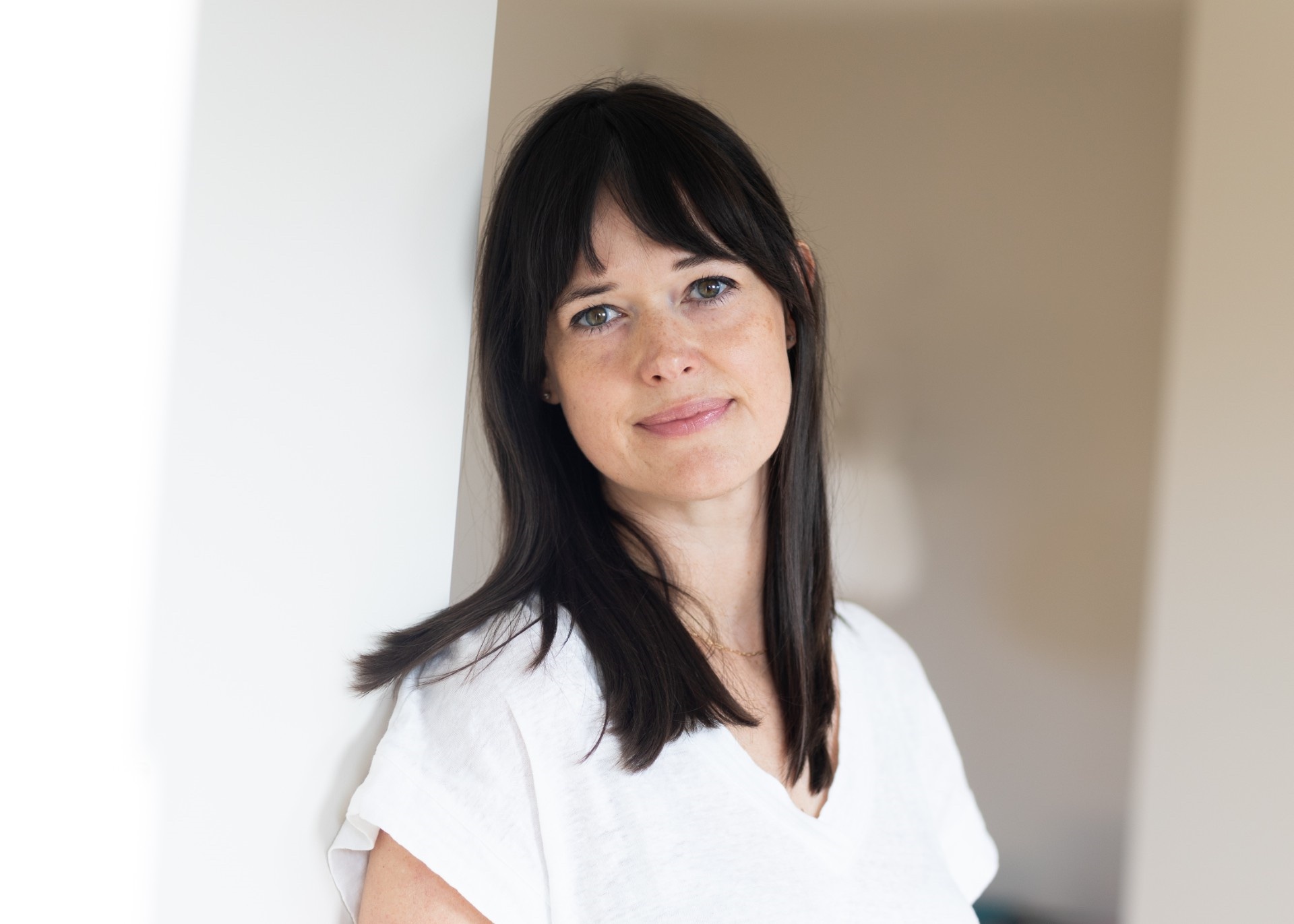 girl on girl author sophie gilbert wearing a white tshirt and smiling posing