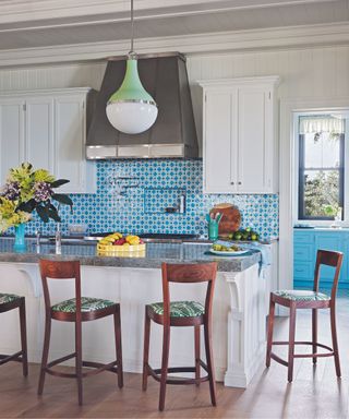 Kitchen with blue backsplash and white cabinets