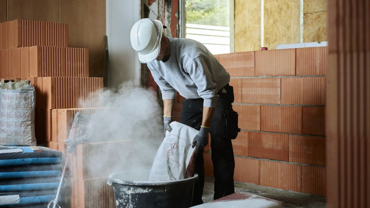 A builder building a house using concrete