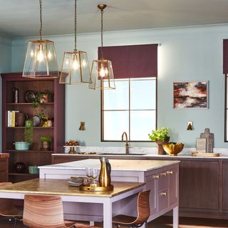 A purple kitchen with pendant lights