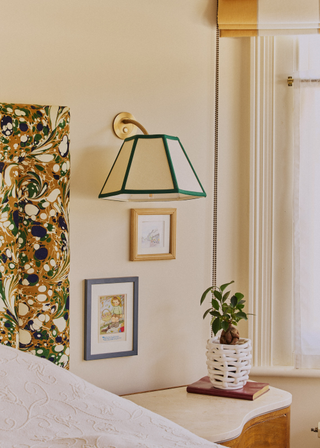 A bedroom with a woven ceramic planter on a bedside table