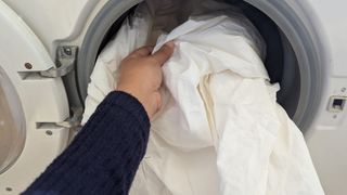 Putting the Coop Percale sheet set into the washing machine