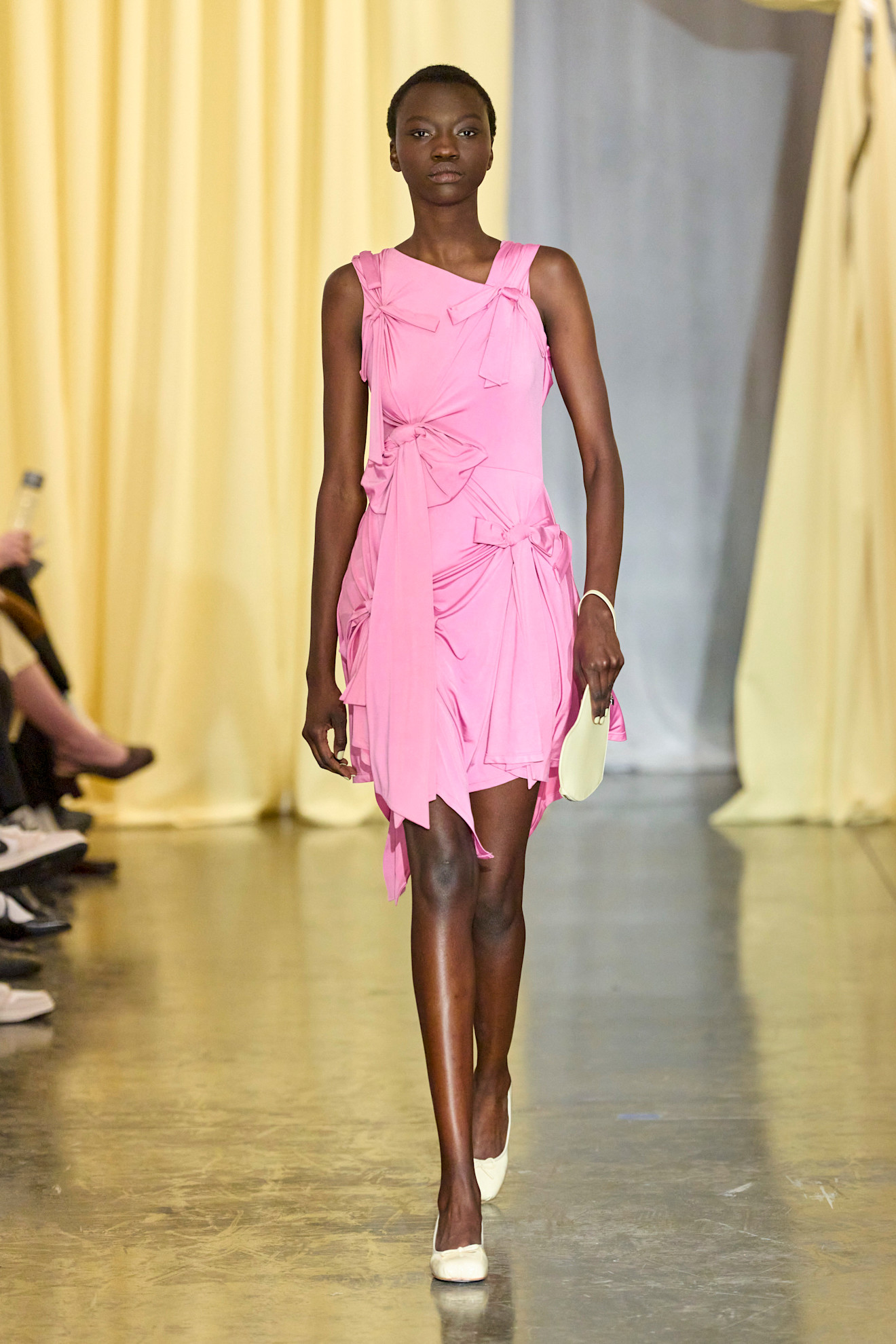 Photo of model walking in the Sandy Liang Fall-Winter 2024 show, wearing pink mini dress with bows.