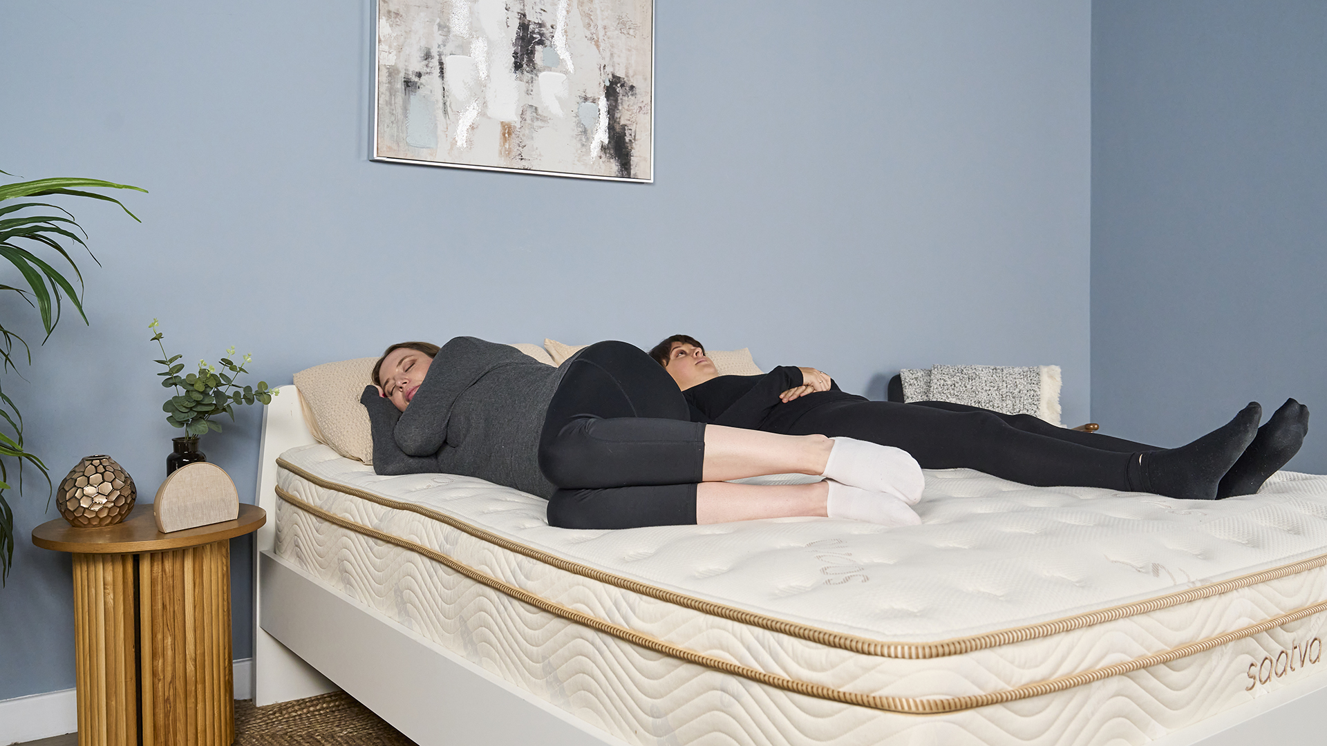 Two of our mattress testers lie on the Saatva Classic during our reviewer-led motion isolation test. Tester A performed a series of standardized physical actions, while Tester B remained lying down on the mattress, dictating notes to our Sleep Lab Lead Claire Davies on any motion she was feeling while Tester A moved around, performing light to very vigorous movements.