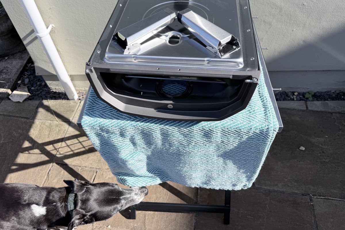 The Ooni Karu 2 being built, with a dog sniffing the pizza oven