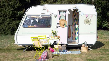 Caravan makeover with garden table and chairs and blanket
