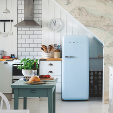  A view into the kitchen from the dining area looking towards the pale blue Smeg fridge.