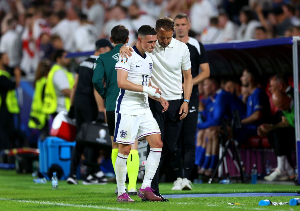 Phil Foden of England interacts with Gareth Southgate, Head Coach of England, as he leaves the field after being replaced by substitute Anthony Gordon (not pictured) during the UEFA EURO 2024 group stage match between England and Slovenia at Cologne Stadium on June 25, 2024 in Cologne, Germany. (Photo by Richard Pelham/Getty Images)