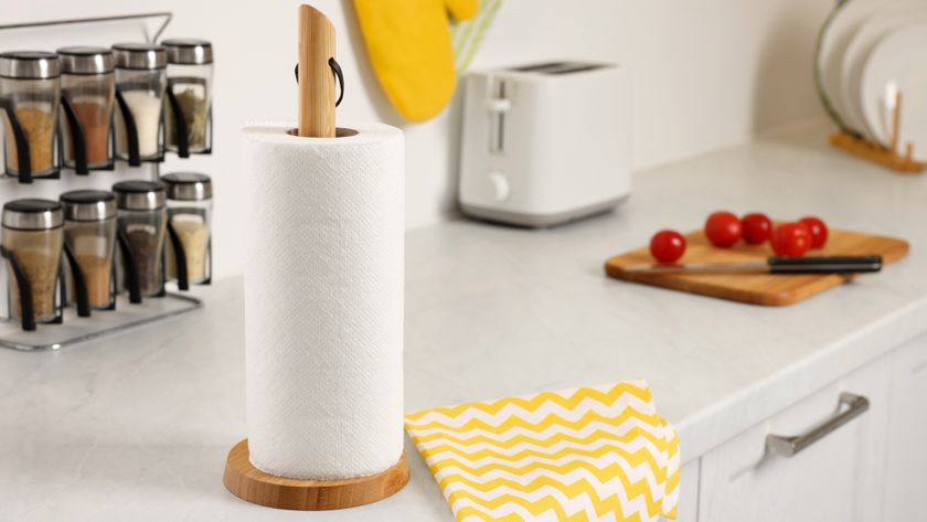 White roll of paper towels next to yellow and white cloth on countertop