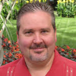 Man with goatee beard smiling to camera