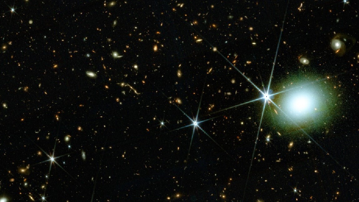 Galaxies on a dark section of sky and a bright white blob toward the right.
