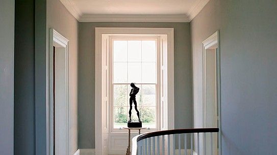 room space with white walls wooden railing and large white window