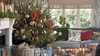 Country style living room with real Christmas tree with paper decorations to show a homespun Christmas tree decorating idea