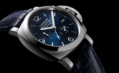 The new Panerai Luminor BiTempo watch with a silver frame, black strap and dark blue vignetted face with white hands.