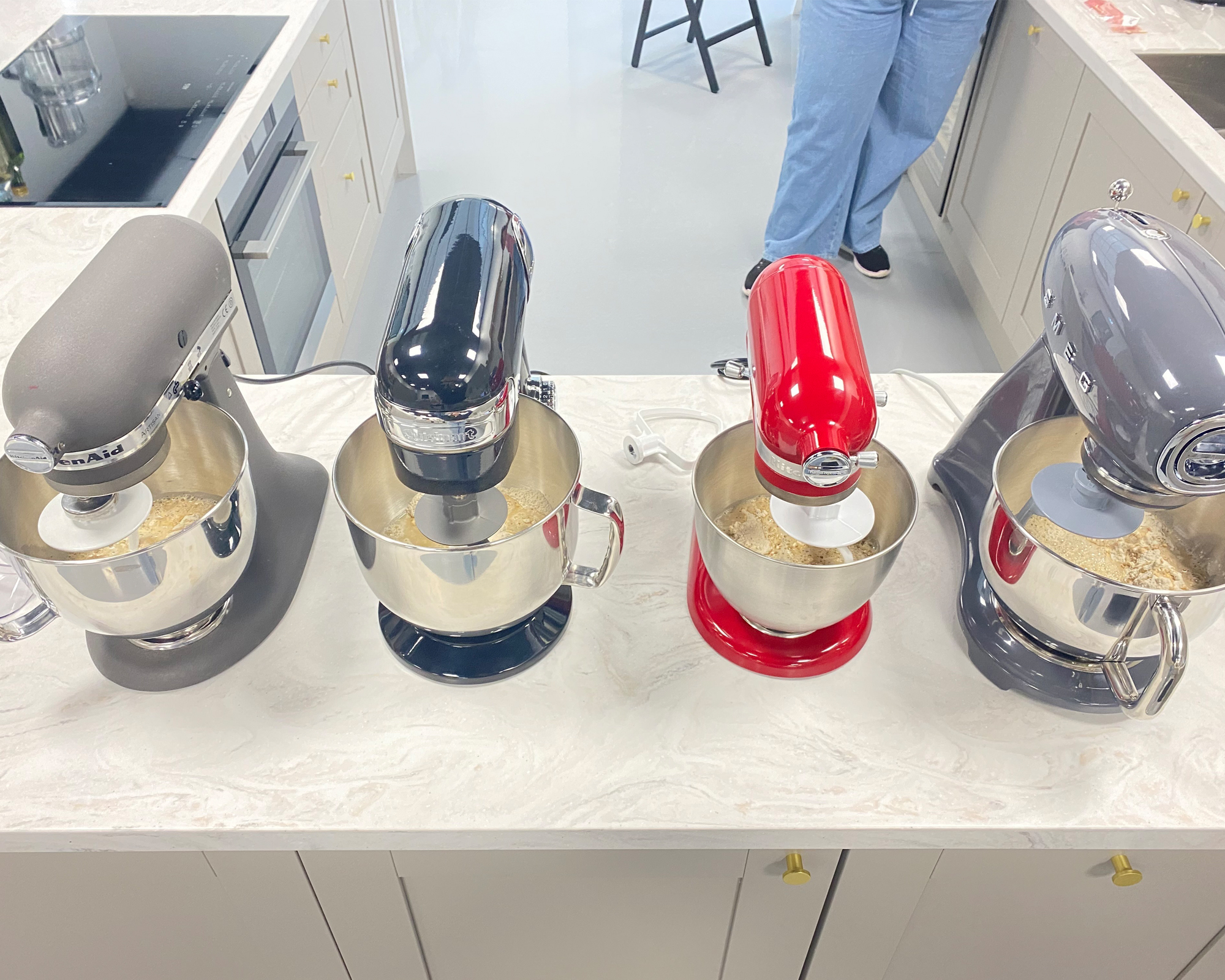 A KitchenAid Artisan, KitchenAid Mini, Cuisinart Precision, and Smeg stand mixers being tested