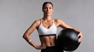 a photo of a strong woman holding a medicine ball
