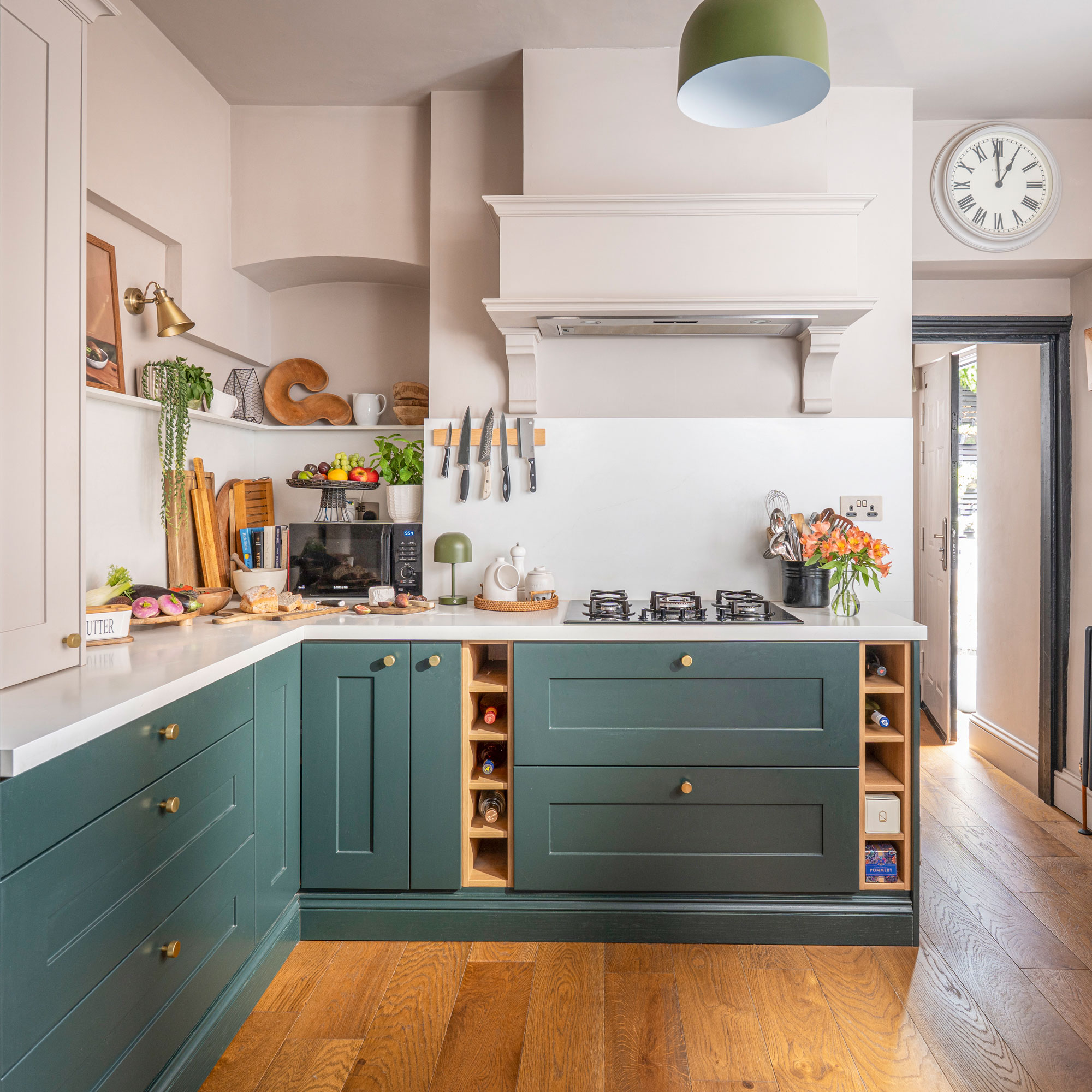 Blue kitchen cabinets with mushroom walls and white splashback