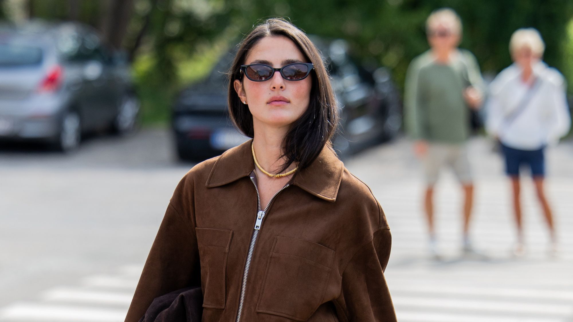 woman with brown hair wearing suede jacket with blushed cheeks
