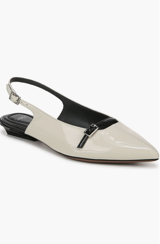 a pair of slingback flats in front of a plain backdrop