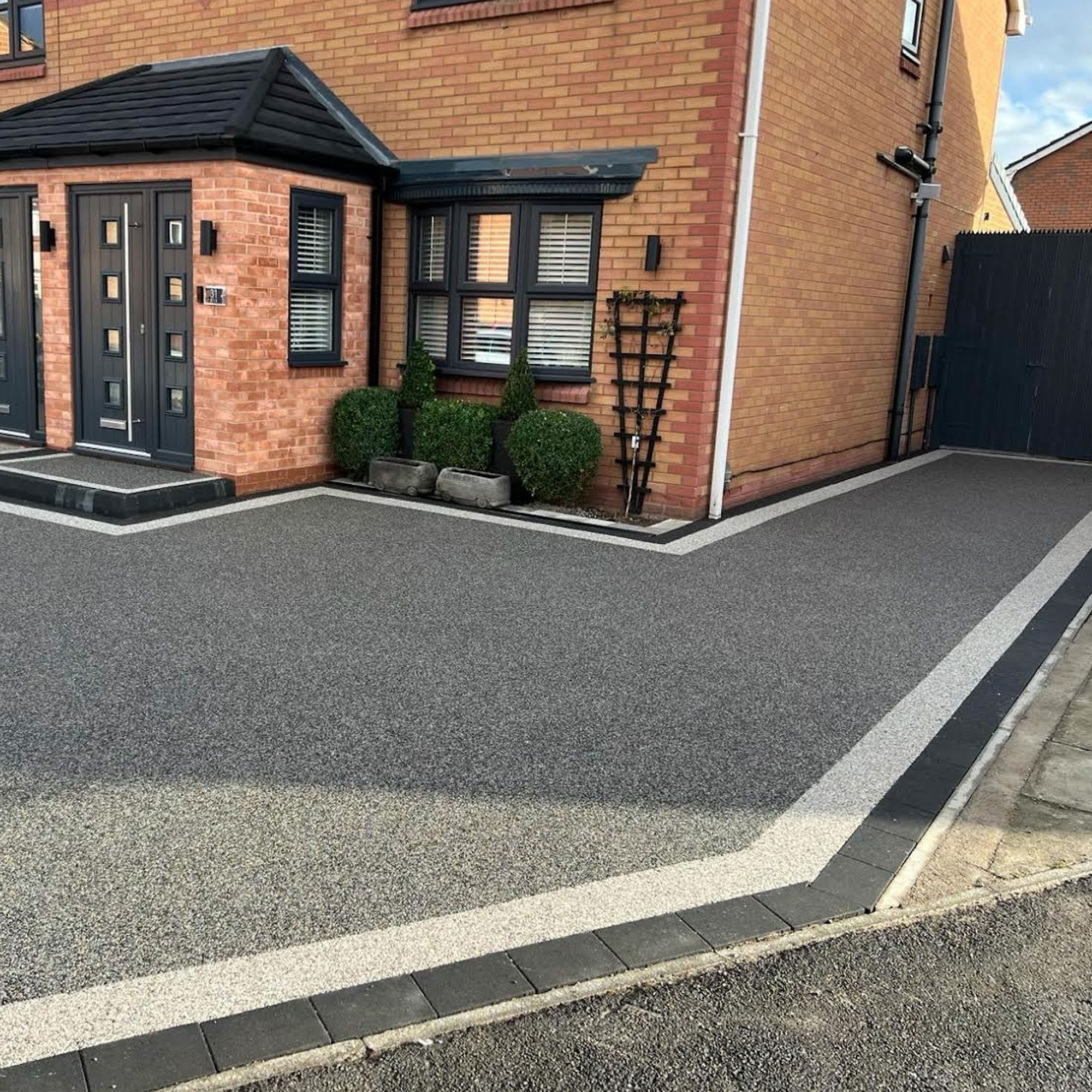 grey resin bound driveway outside modern house