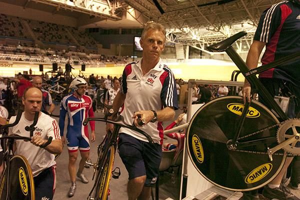 Great Britain's track cycling coach, Shane Sutton, helps his charges get ready for their ride in the men's teams pursuit.