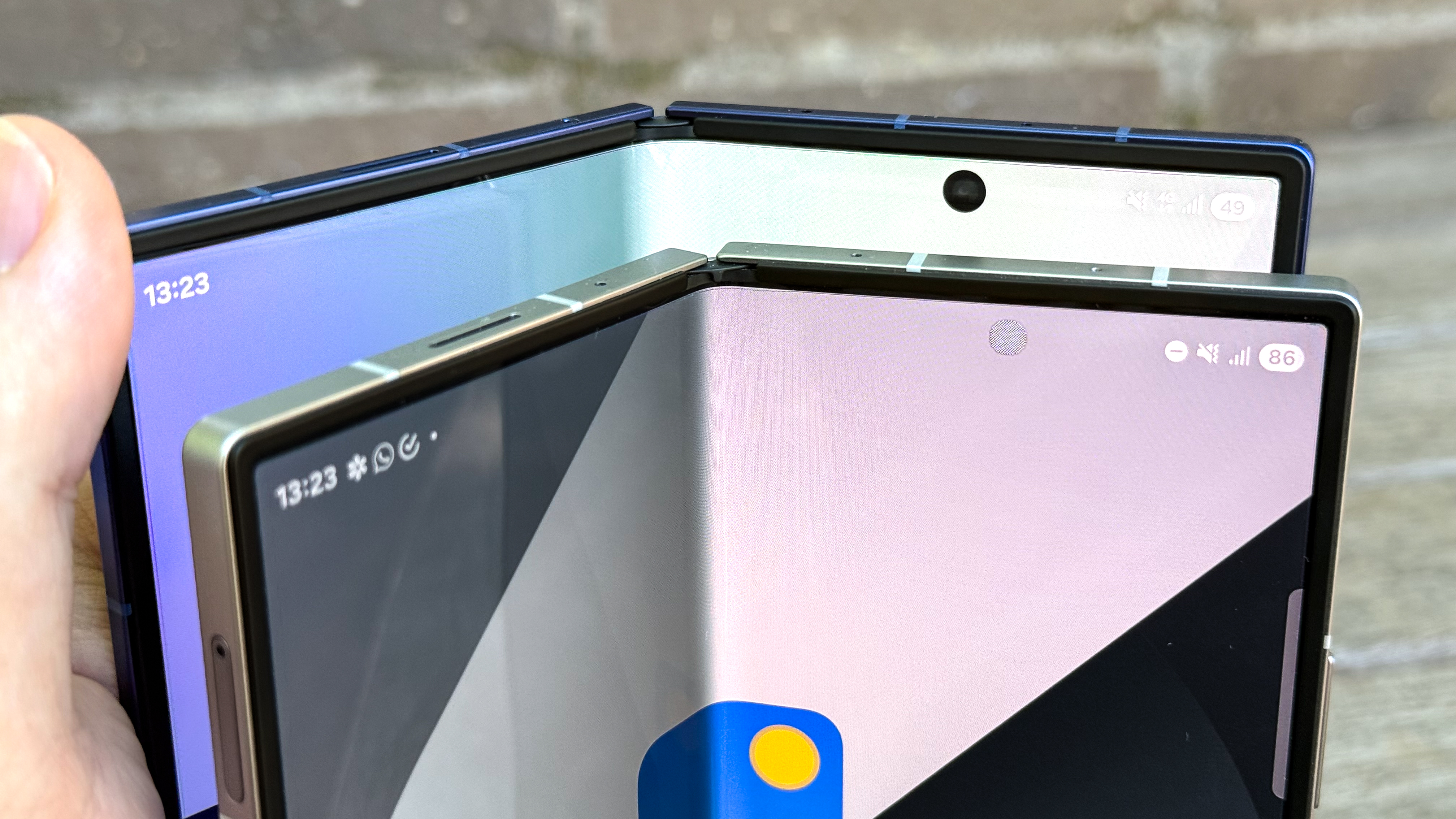 Galaxy Z Fold 7 and Galaxy Z Fold 6 displays and inner cameras shown on a stone wall