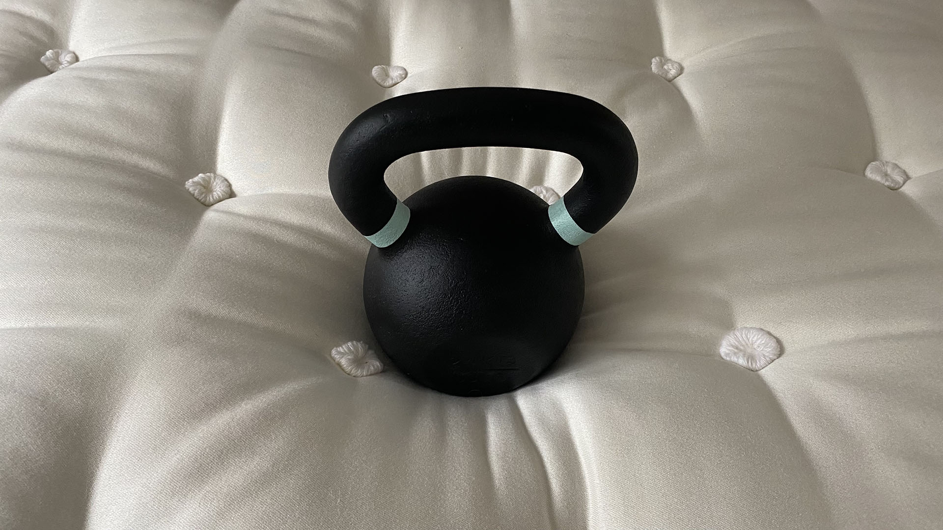 A 24kg kettlebell sitting on the center of the Simba Earth Escape mattress, demonstrating pressure relief