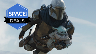 The Mandalorian flying on his jetpack with Grogu under his arm. A Space Deals logo is over the picture. 