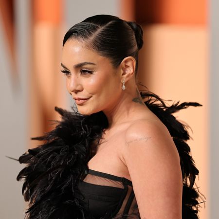 a woman with dark hair wearing a black dress on a red carpet