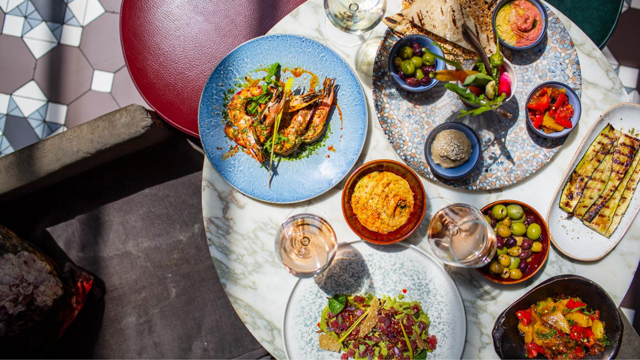 Table with mezze food and glasses of wine