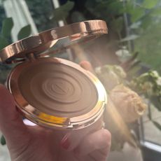 a hand holding charlotte tilbury sunkissed bronzer