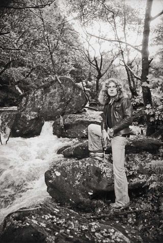 Robert Plant standing next to a small stream