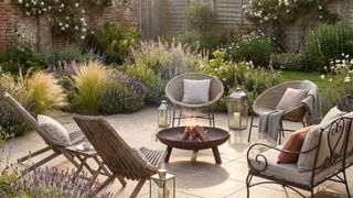 light paved patio area with seating, fire pit and heavily planted garden borders