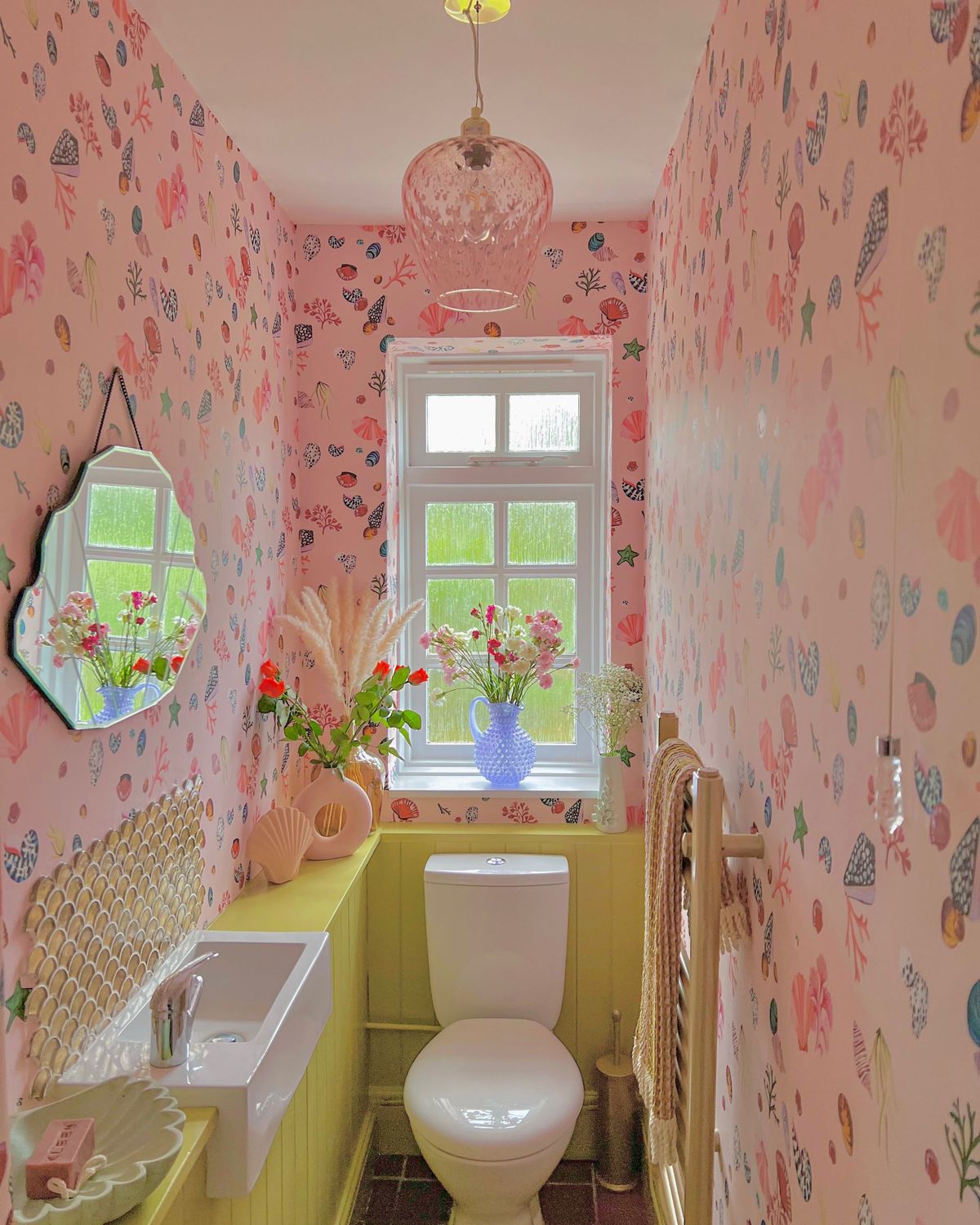 Upstairs toilet with pink design, including pink walls, sink and curtains