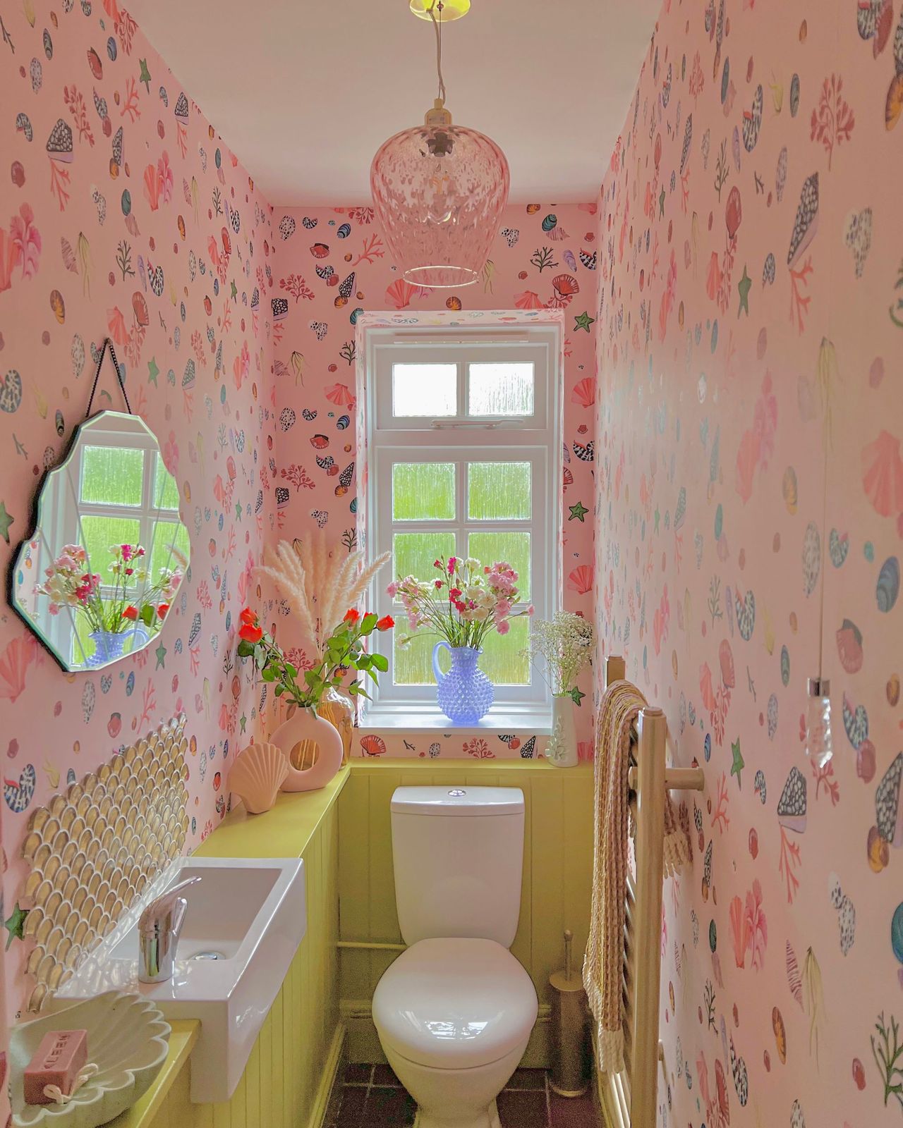 Upstairs toilet with pink design, including pink walls, sink and curtains