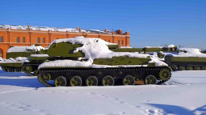 An obsolete Russian tank is covered in snow